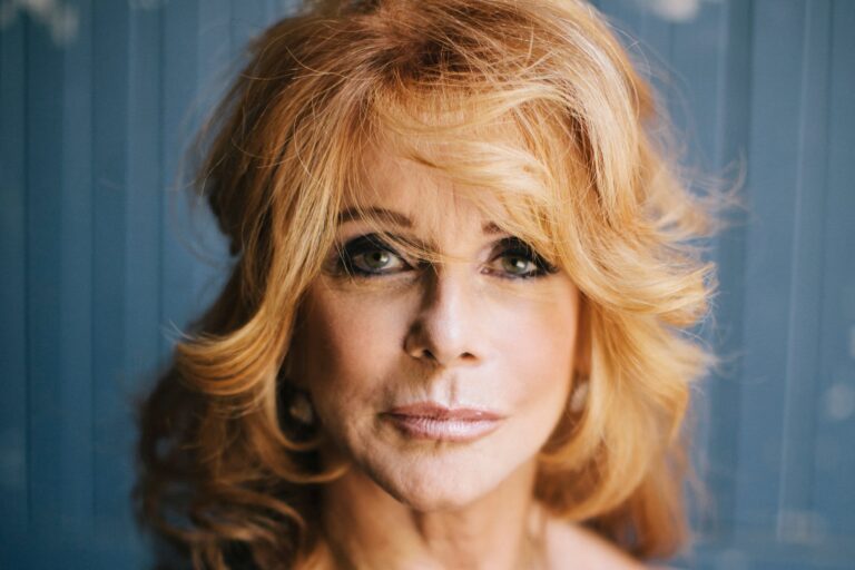 Ann-Margret, actriz y cantante, sonriendo en un evento público.