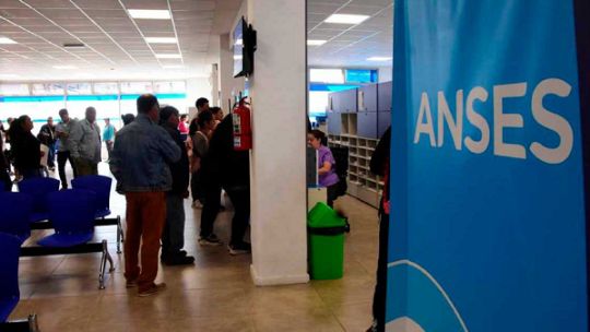 Calendario de pagos de ANSES sobre escritorio con computadora y documentos
