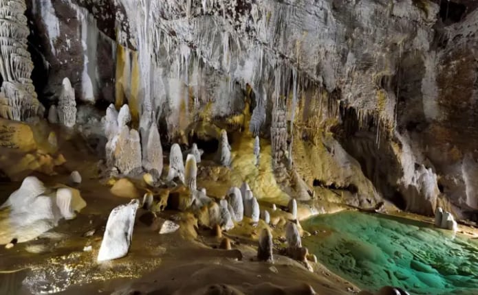 Interior de la cueva de Lechuguilla, México, con formaciones rocosas y un científico realizando investigaciones.