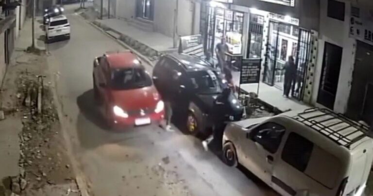 Captura de cámara de seguridad que muestra el momento del impacto entre el auto rojo y el delincuente en una calle de Lomas de Zamora.