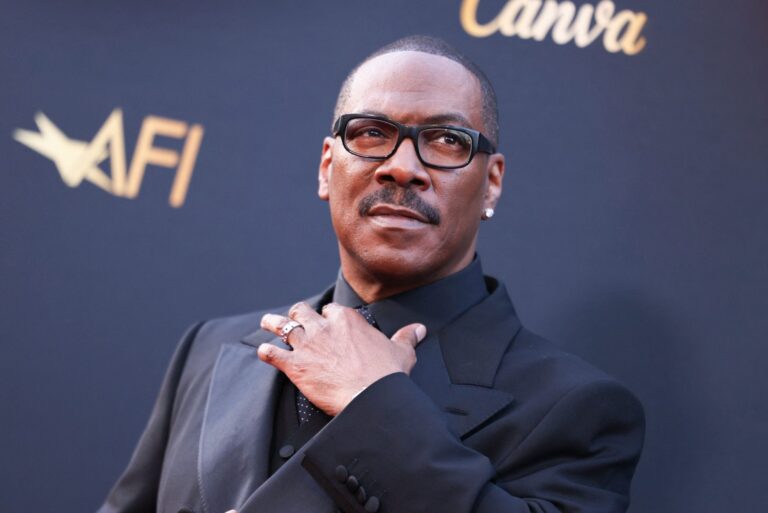 Eddie Murphy sostiene el premio a la trayectoria del AFI en el escenario del teatro Dolby, rodeado de colegas.