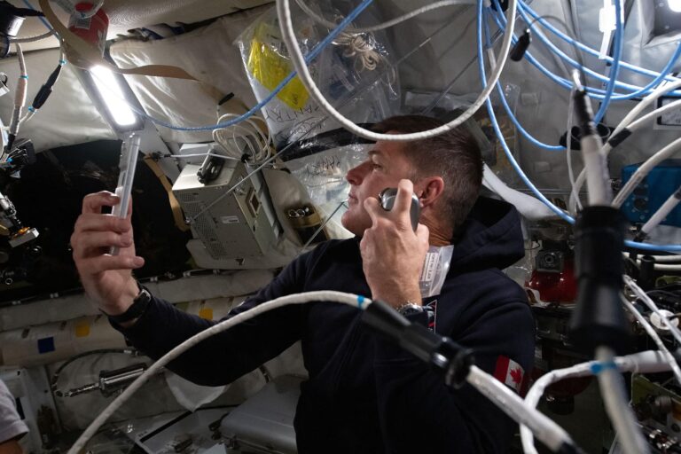 Astronauta de la misión Artemis II sosteniendo un iPhone 17 Pro Max en el interior de la nave espacial.