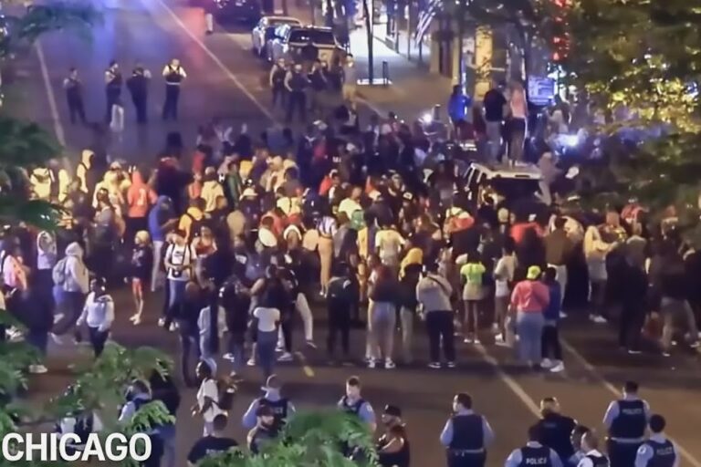 Grupo de jóvenes reunidos en un espacio público urbano durante la noche.