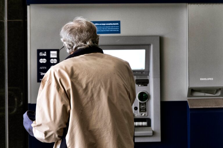 Personas frente a un banco con cartel de cerrado por paro gremial