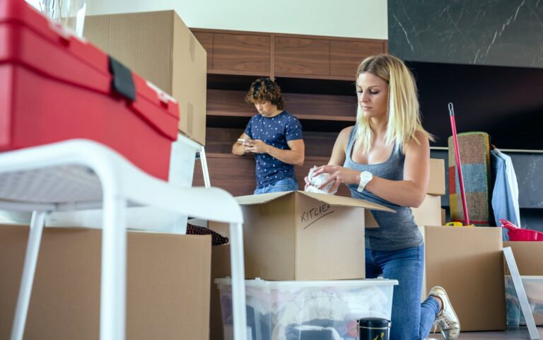Hombre y mujer analizando planos de una casa junto a un corredor inmobiliario