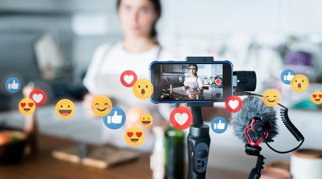 Persona trabajando en la creación de contenido digital en una computadora y con un celular
