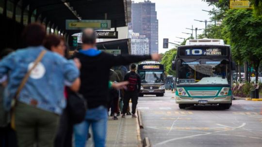 Colectivo en una parada con pasajeros esperando en el AMBA