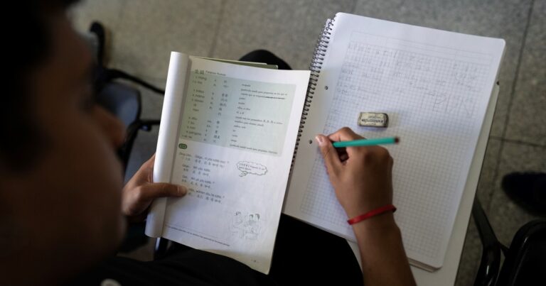 Persona practicando escritura de caracteres chinos en un cuaderno