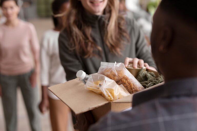 Personas recibiendo bolsas de comida gratuita en un operativo de Food Bank For New York City