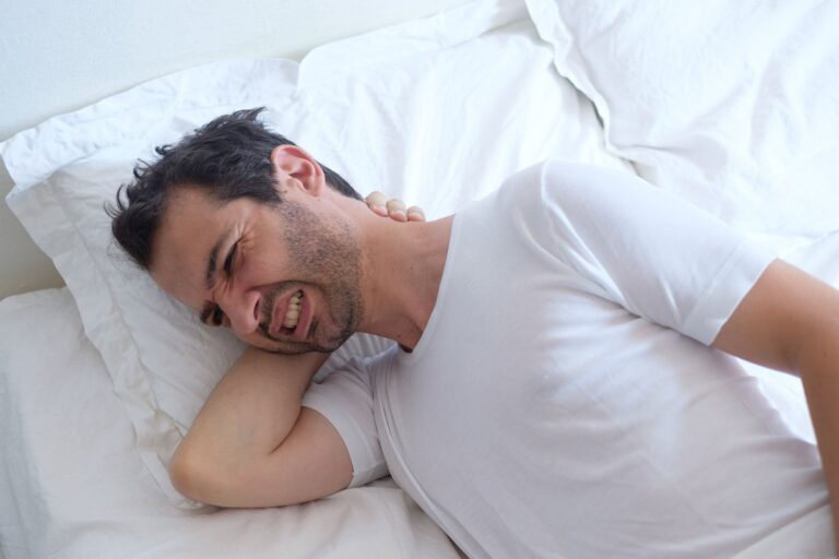 Persona durmiendo con almohada ergonómica en ambiente oscuro y fresco