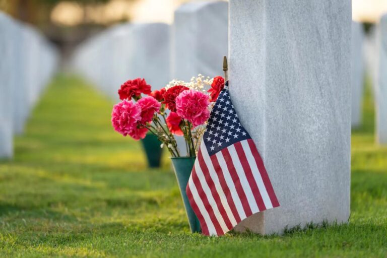 Bandera de Estados Unidos en cementerio militar con flores en tumbas