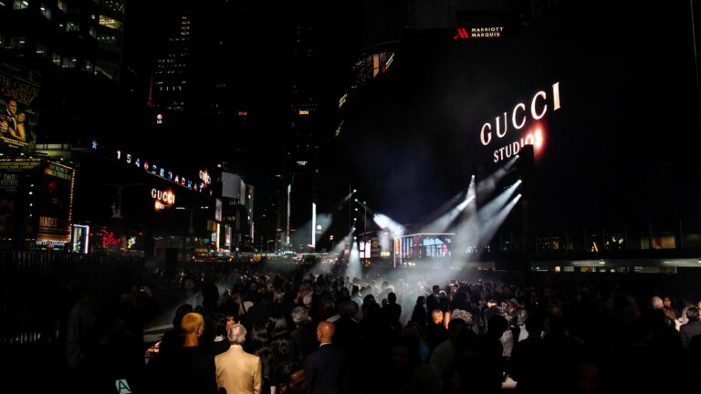 Desfile de Gucci en Times Square con pantallas electrónicas y celebridades
