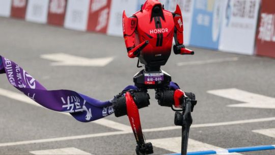 Robot humanoide corriendo en una media maratón en Beijing, rodeado de otros participantes