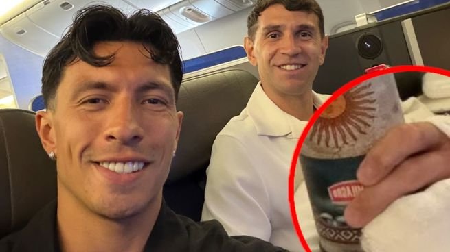 Emiliano Dibu Martínez con vendaje en la mano derecha junto a Lisandro Martínez en un avión