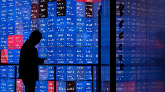 Gráfico de mercados bursátiles con barril de petróleo y símbolo de inteligencia artificial