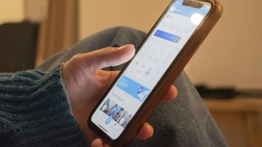Persona usando un teléfono celular en un entorno doméstico