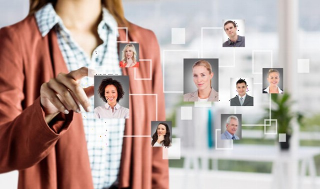 Personas trabajando en oficina con dispositivos digitales y gráficos de gestión de recursos humanos