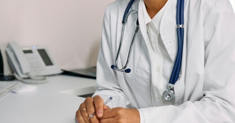 Médico con estetoscopio frente a un hospital en Estados Unidos