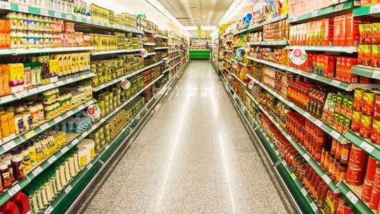 Góndola de supermercado con productos alimenticios y etiquetas de precios
