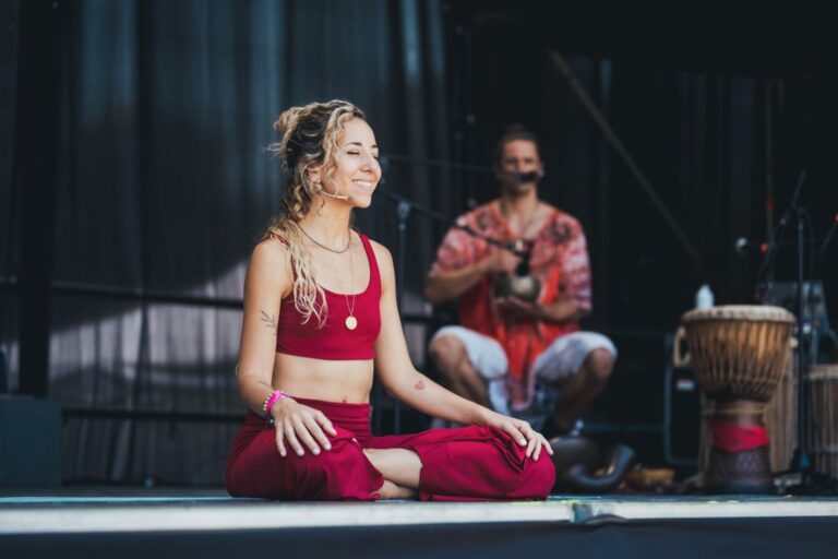 Personas practicando yoga al aire libre en un evento con música en vivo