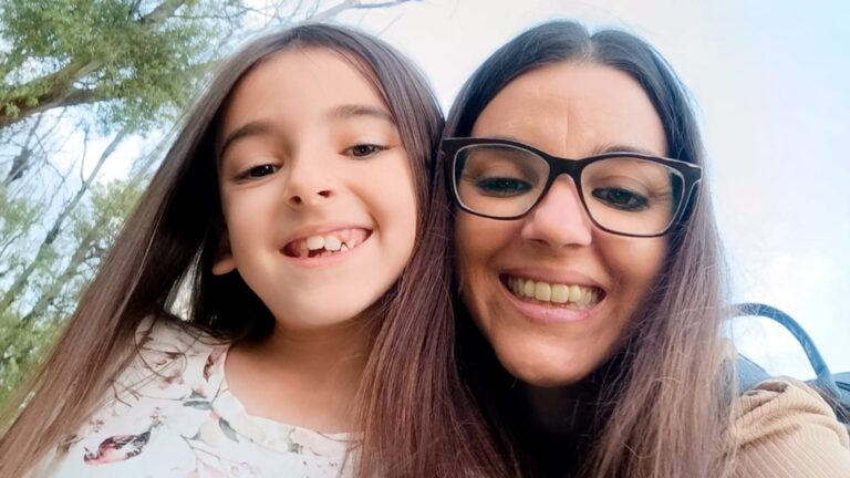 Niña sonriente con una lapicera de hormona de crecimiento en la mano
