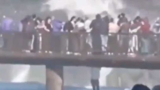 Turista colgado de pasarela en Cataratas del Iguazú