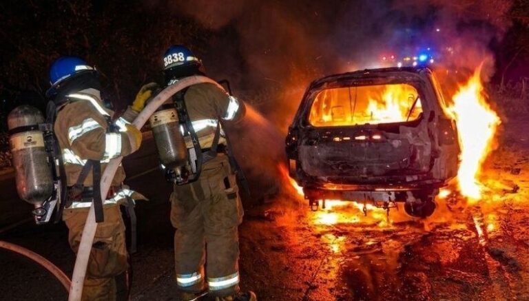 Bomberos de El Salvador trabajan en la extinción de un incendio vehicular en la Carretera Panamericana