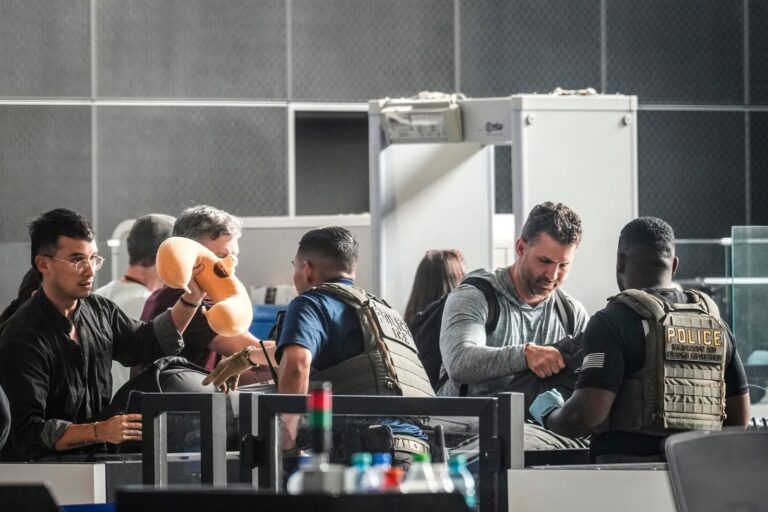 Vista de un aeropuerto con agentes de seguridad y viajeros