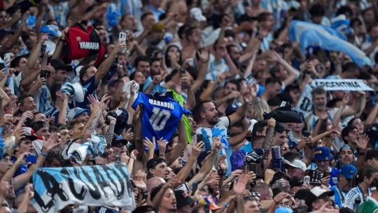 Aficionados argentinos celebrando durante un partido de fútbol en un bar