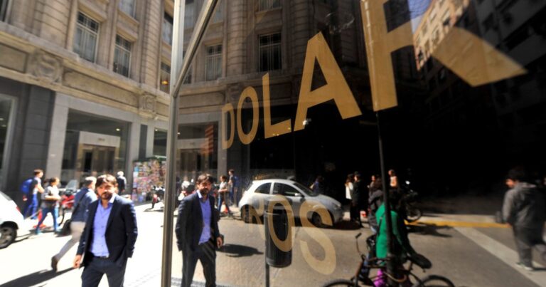Billetes de dólar azul y argentinos sobre una superficie
