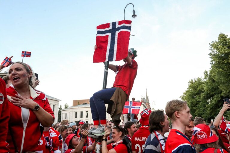 Multitud de hinchas noruegos en la calle Karl Johans de Oslo realizando el gesto de remo vikingo