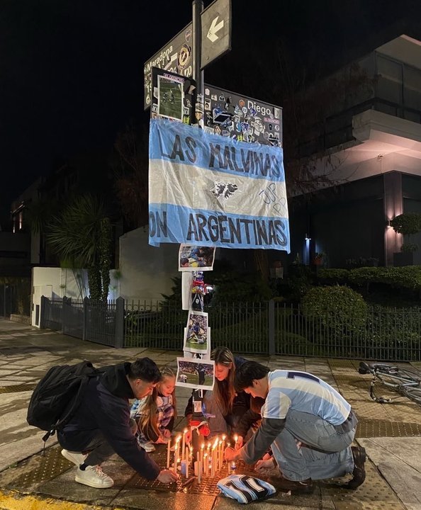 Esquina de Segurola y Habana con velas, bandera argentina y leyenda Las Malvinas son Argentinas