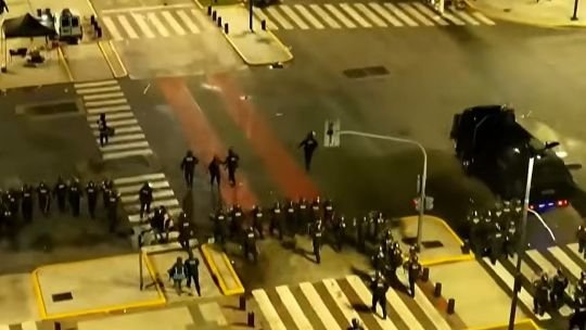 Personas corriendo en el Obelisco durante incidentes tras la final del Mundial de fútbol entre Argentina y España