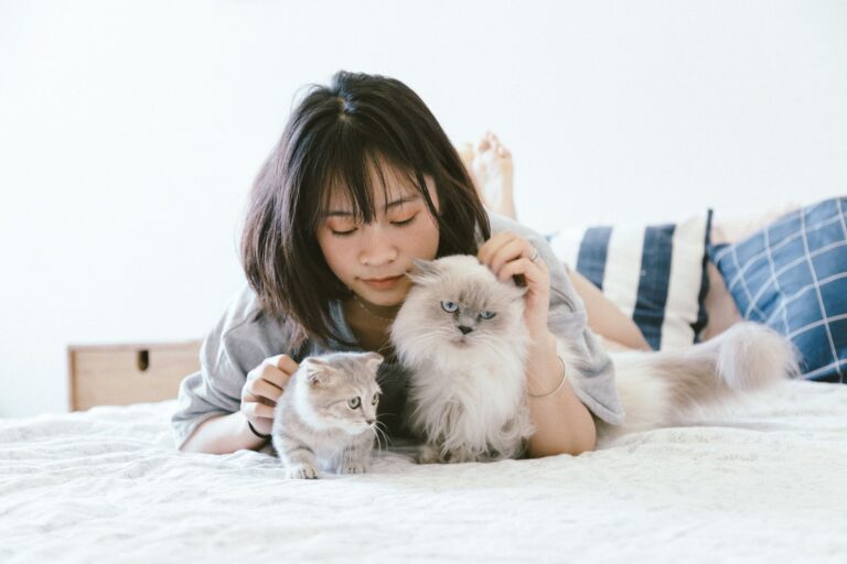 Persona durmiendo con un gato en la cama