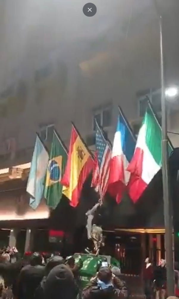 Manifestantes incendiando una bandera de Estados Unidos frente al Congreso