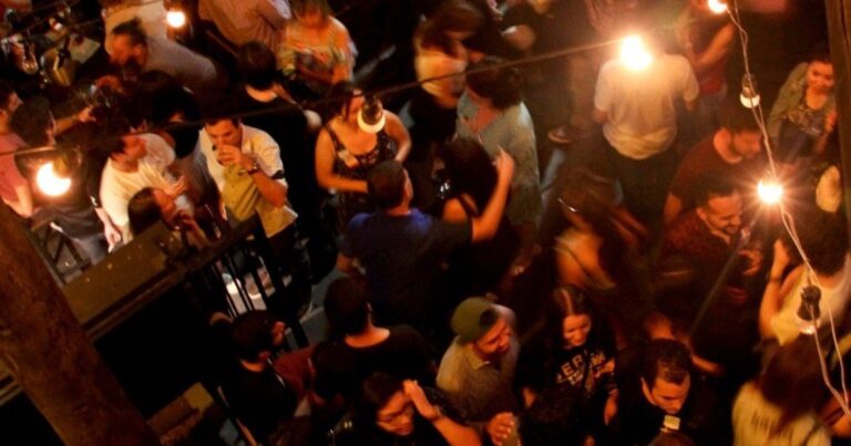 Personas con banderas adhesivas en un evento de Mundo Lingo en un bar de Buenos Aires